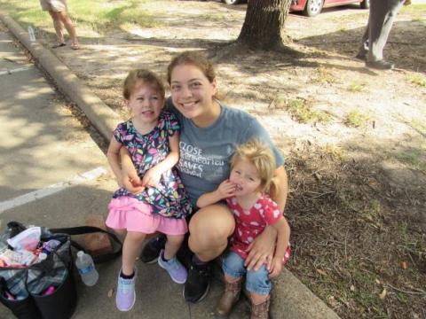 mom and daughters sitting on curb